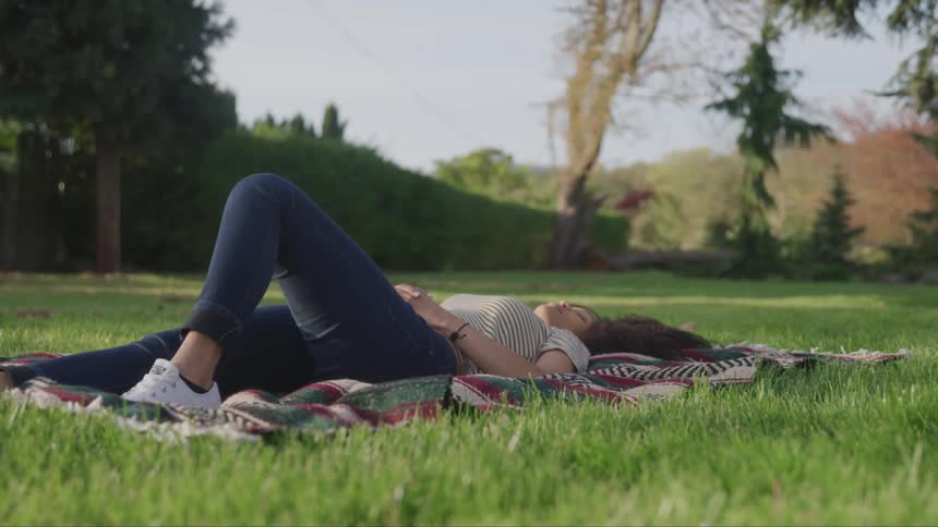 A woman is relaxing on a blanket outdoors in spring