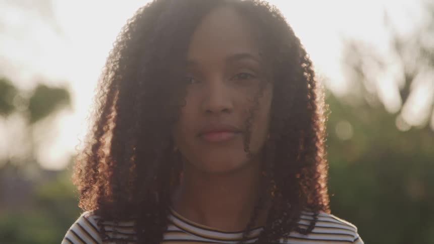 A teenage girl posing for a portrait smiles