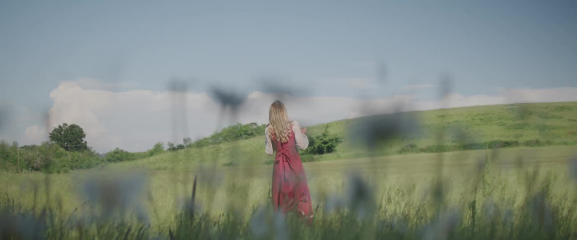 A woman is walking through a meadow