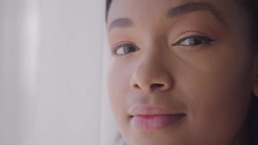 A teenage girl by a window at home