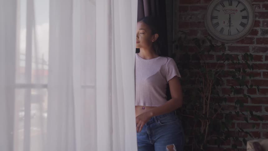 A woman is smiling as she looks out the window