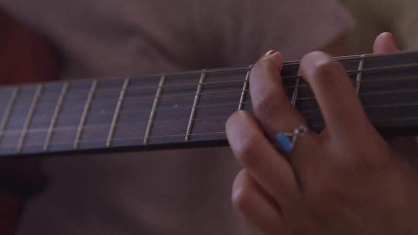A woman is playing guitar indoors