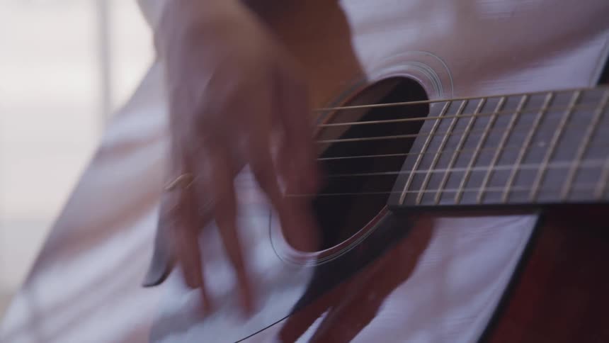 A person is playing guitar indoors