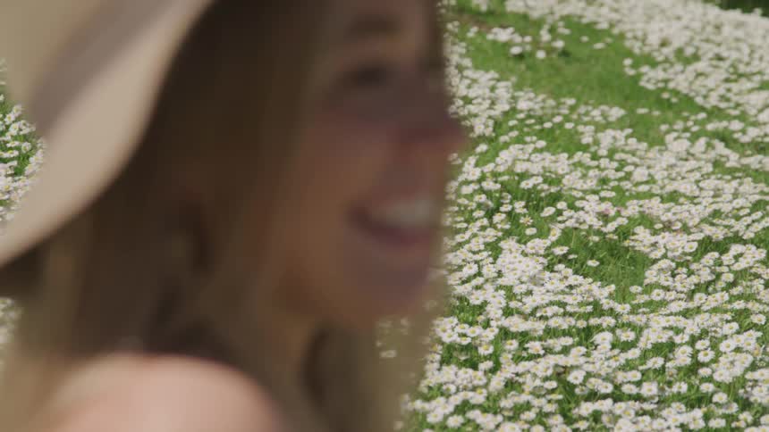 A woman is relaxing outdoors next to flowers