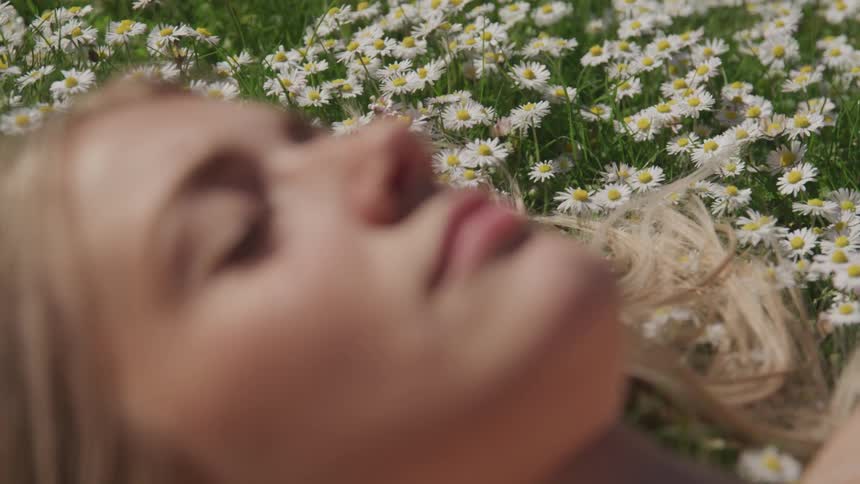 A woman is laying in the grass outdoors in spring