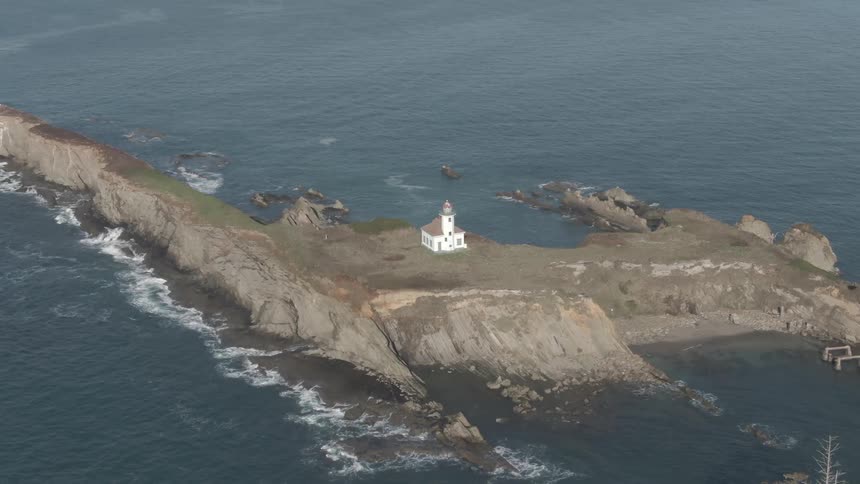 A building in an island surrounded by water with waves