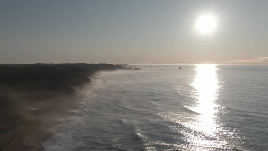 Sun over coastline and water