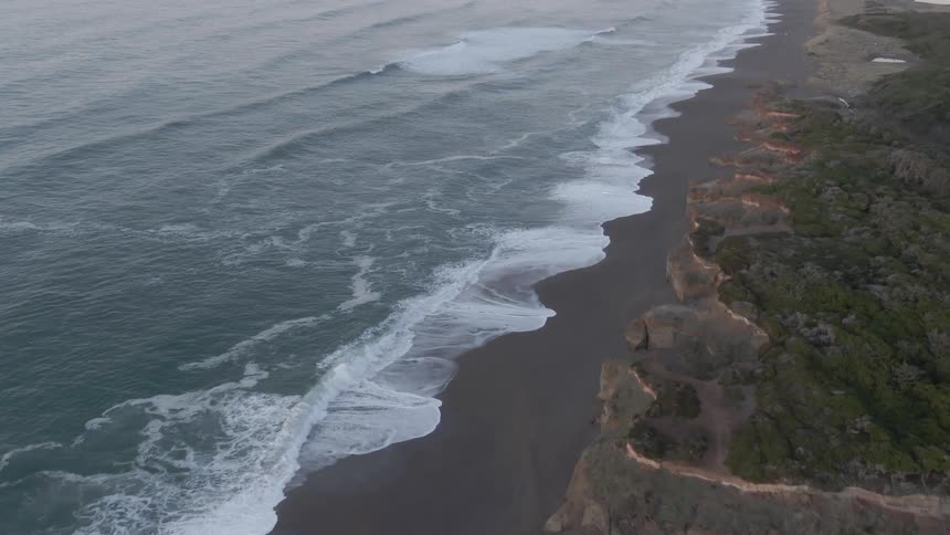Aerial view of waves crashing on a beach at the evening