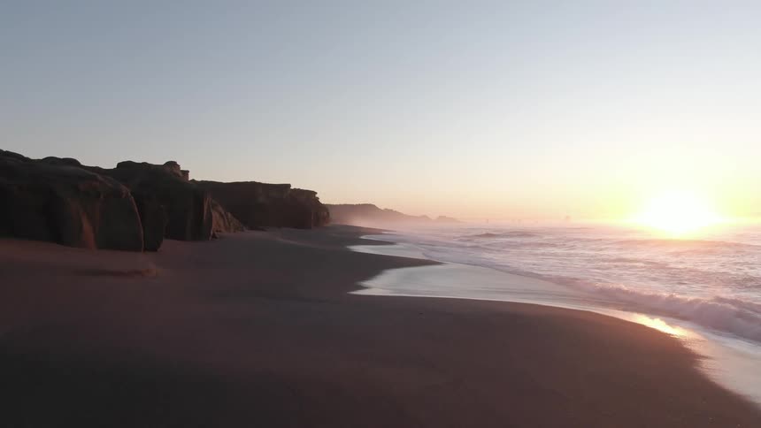 Waves rolling in to the shore as the sun sets