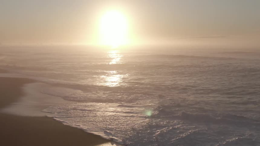 The sun is setting above the beach
