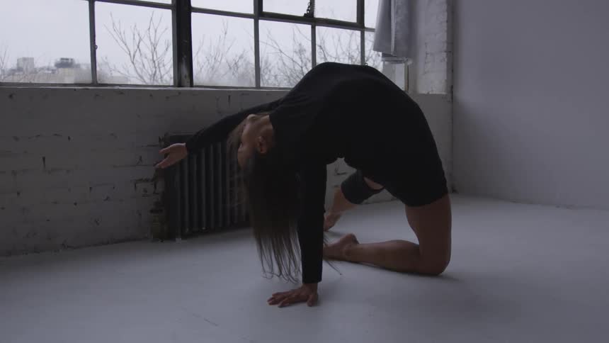 A woman practicing yoga in a room