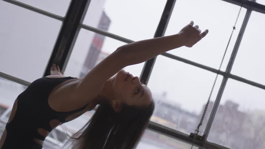 A woman dancing in a studio in a body suit
