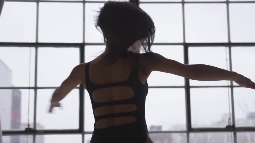 A woman is practicing ballet indoors