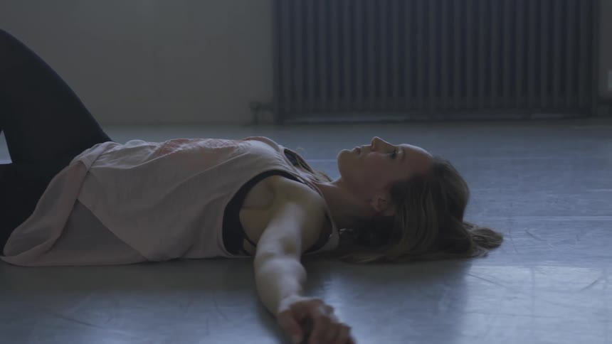 A woman is doing yoga in an empty room