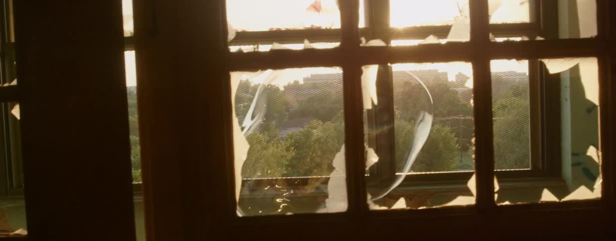 A large bubble floats along a passageway lined with broken windows