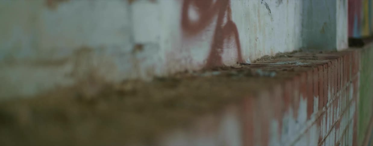Close up of loose brown dirt over the ledge of a red brick wall