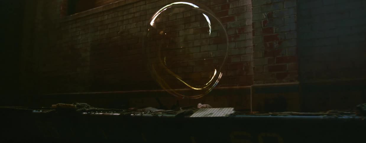 A large bubble floats above an abandoned indoor swimming pool