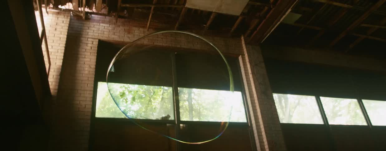 A large bubble floats and then pops inside a building