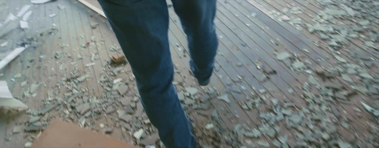 A caucasian female walking inside a dilapidated house
