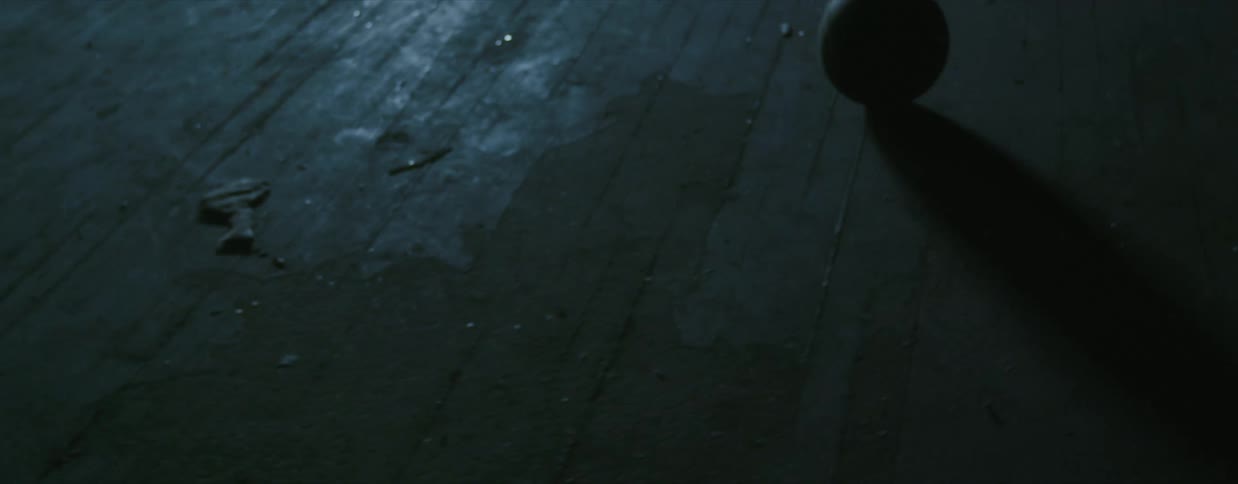A person is kicking a ball around the dark court