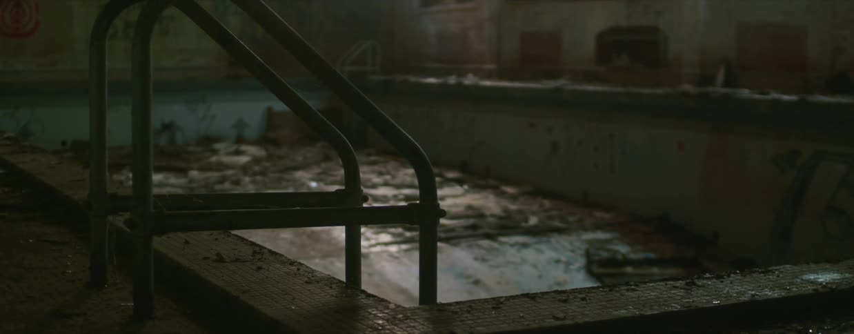 A dilapidated swimming pool in an abandoned building
