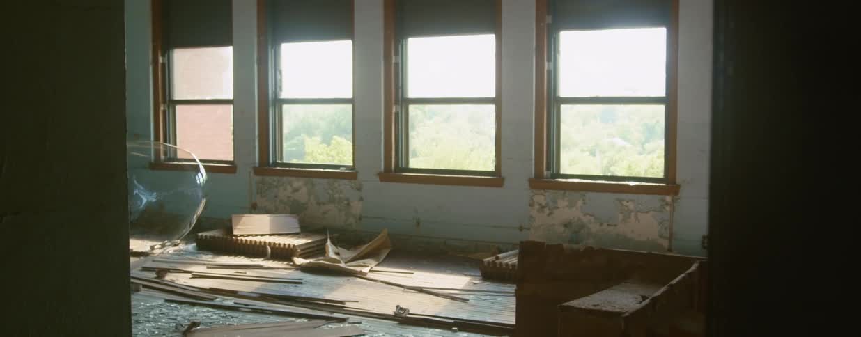 A large bubble floating and popping inside an abandoned building
