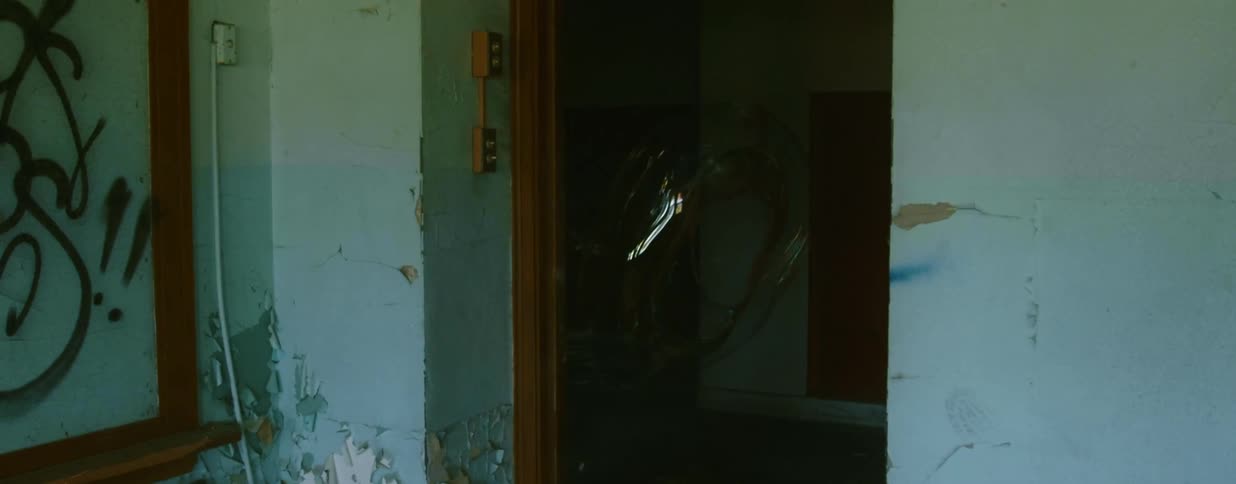 A bubble inside a building with graffiti and peeling paint disappears in to thin air