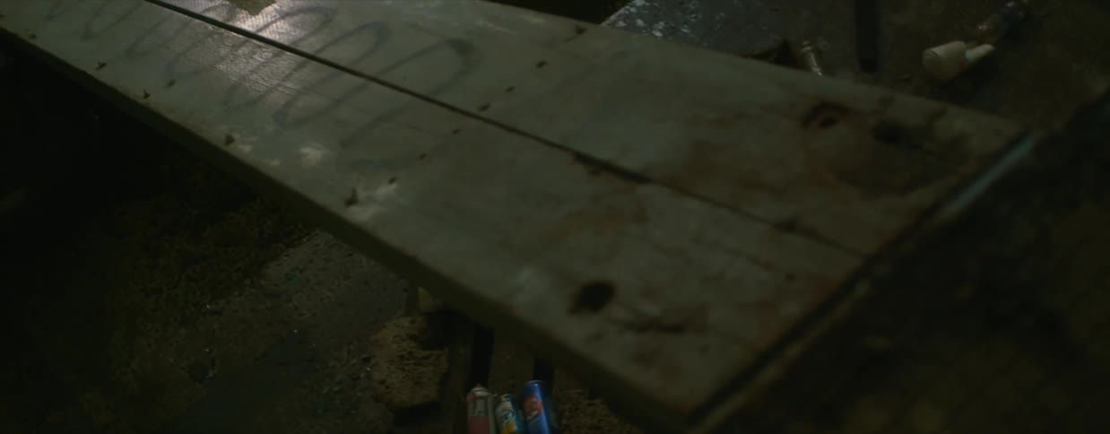 A garage workshop is littered with beer cans and other trash