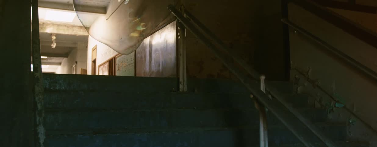 A large bubble in a staircase in a beaten up building pops