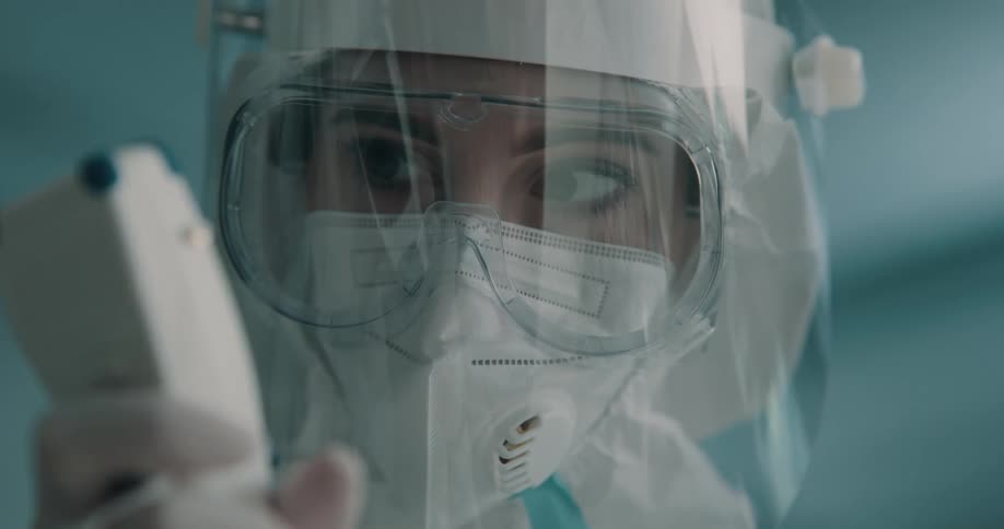 A female wearing a hazmat suit reading a meter