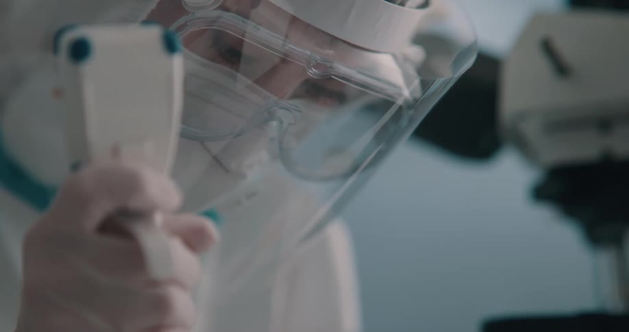 Technician wearing a hazmat suits handles samples on a laboratory