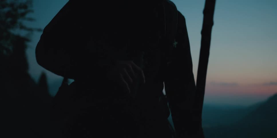 A man is hiking outdoors at dusk