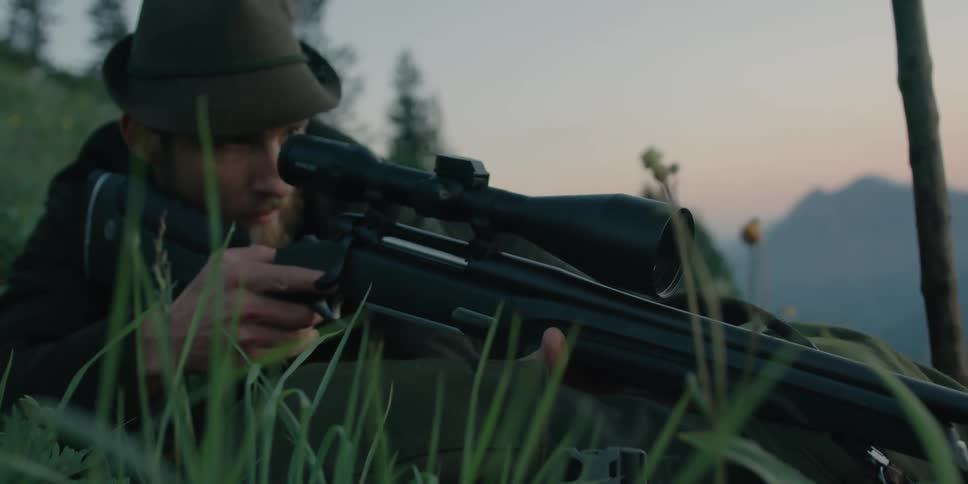 A man aims his sniper rifle on the hill