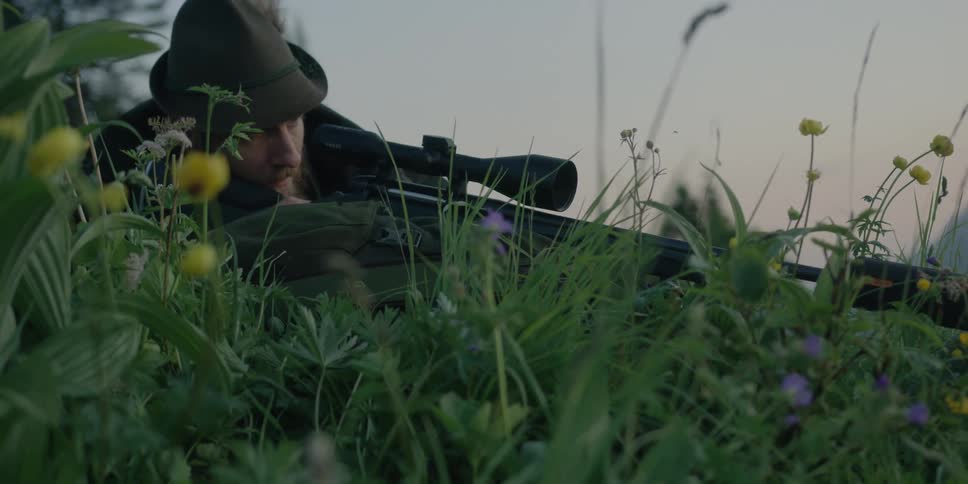 Manlaying in grass fires hunting rifle