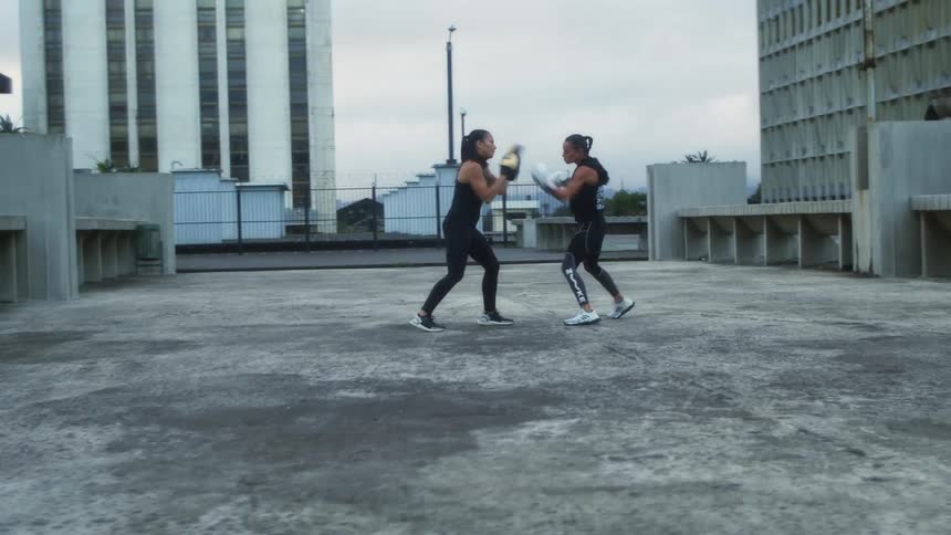 Two woman are boxing in a city