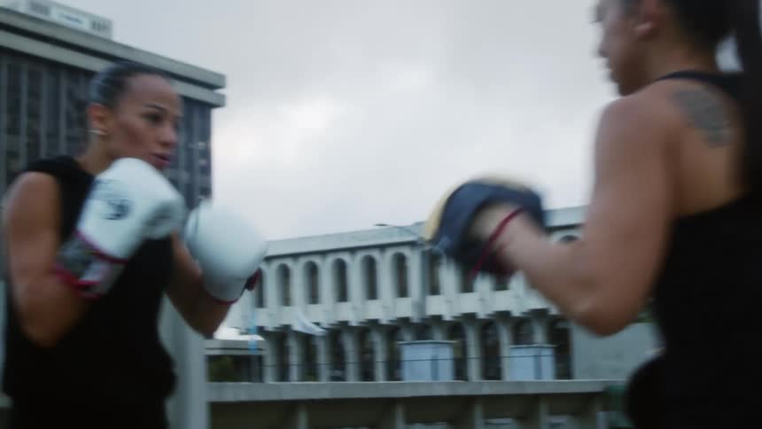 Two women are boxing in a city