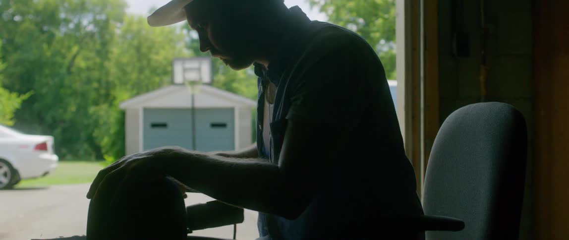 A man working out of his garage makes hats