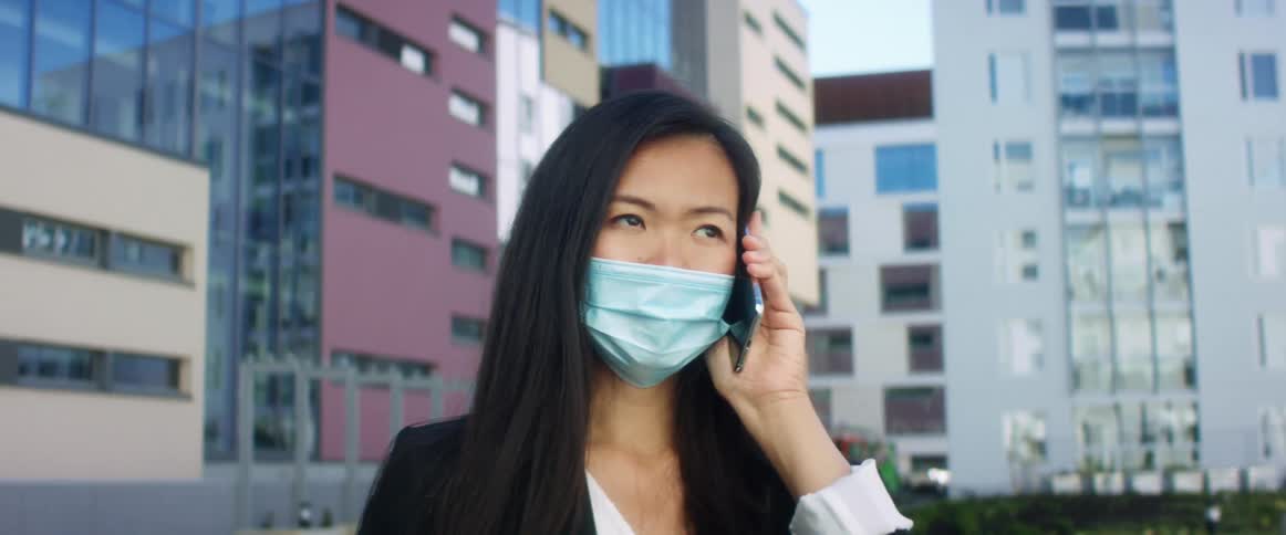 Woman talking on cell phone outside modern office building