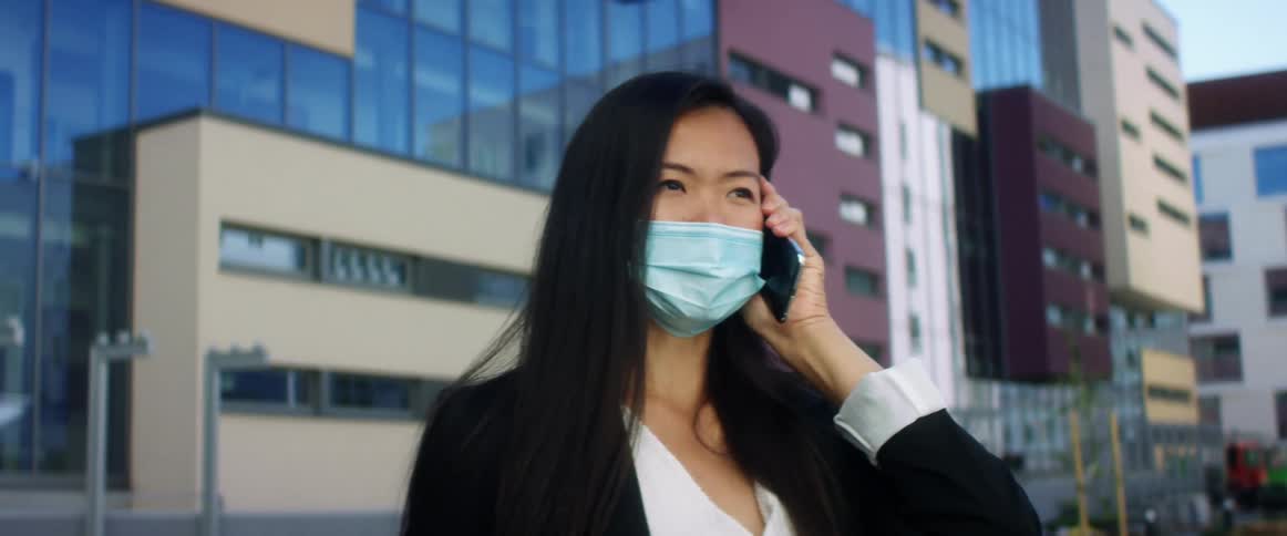 A woman is wearing a mask in a downtown city