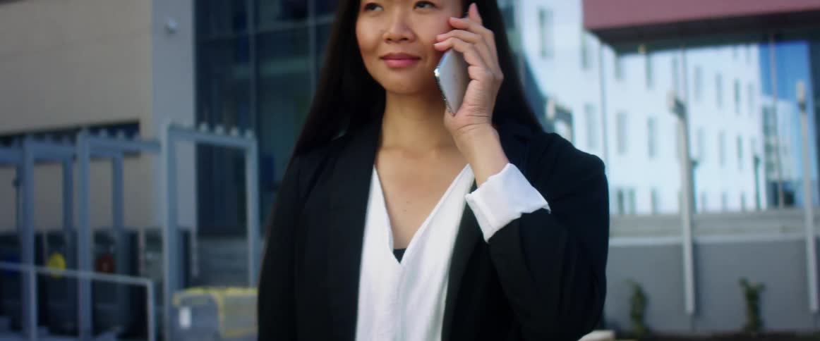 A woman is in a building and talking on a cellphone