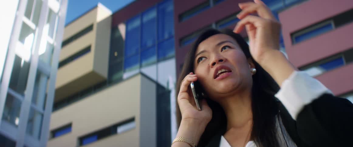 A woman in a downtown area talks on her cell phone