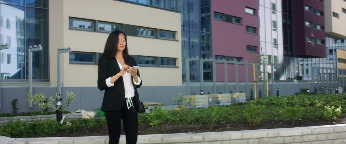 A woman is standing outdoors in a city