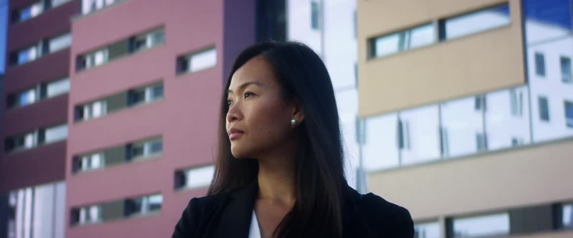 A young woman standing outside of office buildings