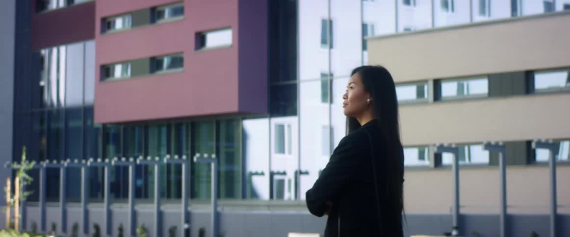 Woman standing outside a building with arms crossed