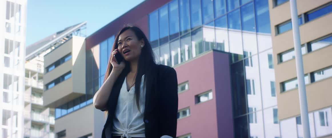 A woman is walking and talking on her cell phone