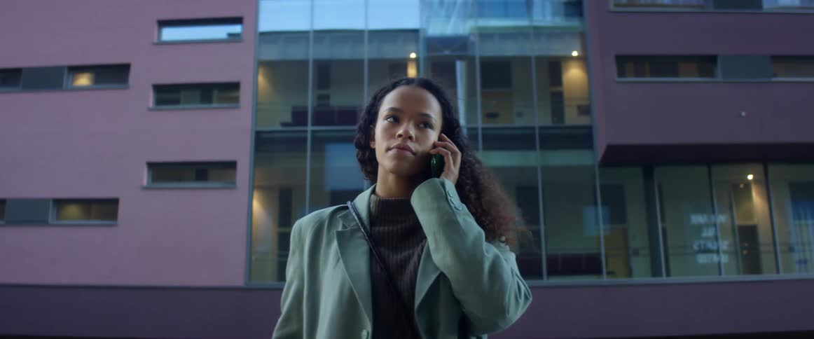 A black woman speaks on her cell phone in a downtown city area