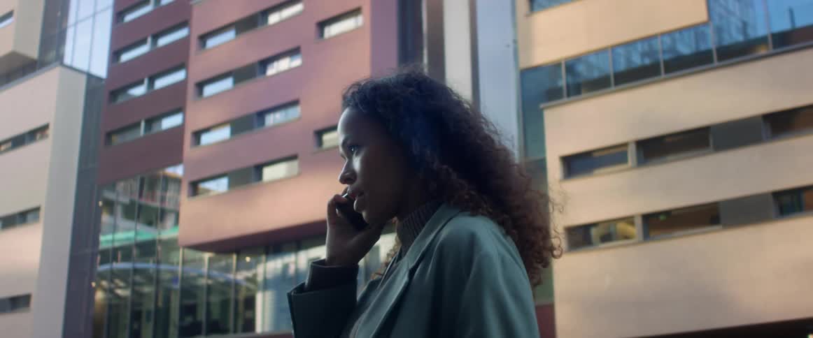 A woman is talking on the phone in a city
