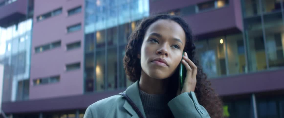 A woman is talking on a cell phone in a downtown city