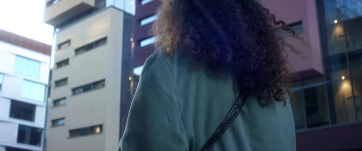 A woman is walking through a downtown city