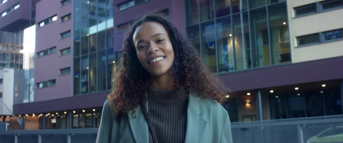 A woman is smiling in a downtown city
